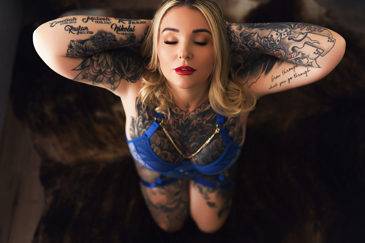 Boudoir client in blue lingerie kneeling on the floor, calm and serene. Photo sessions on the Gold Coast.