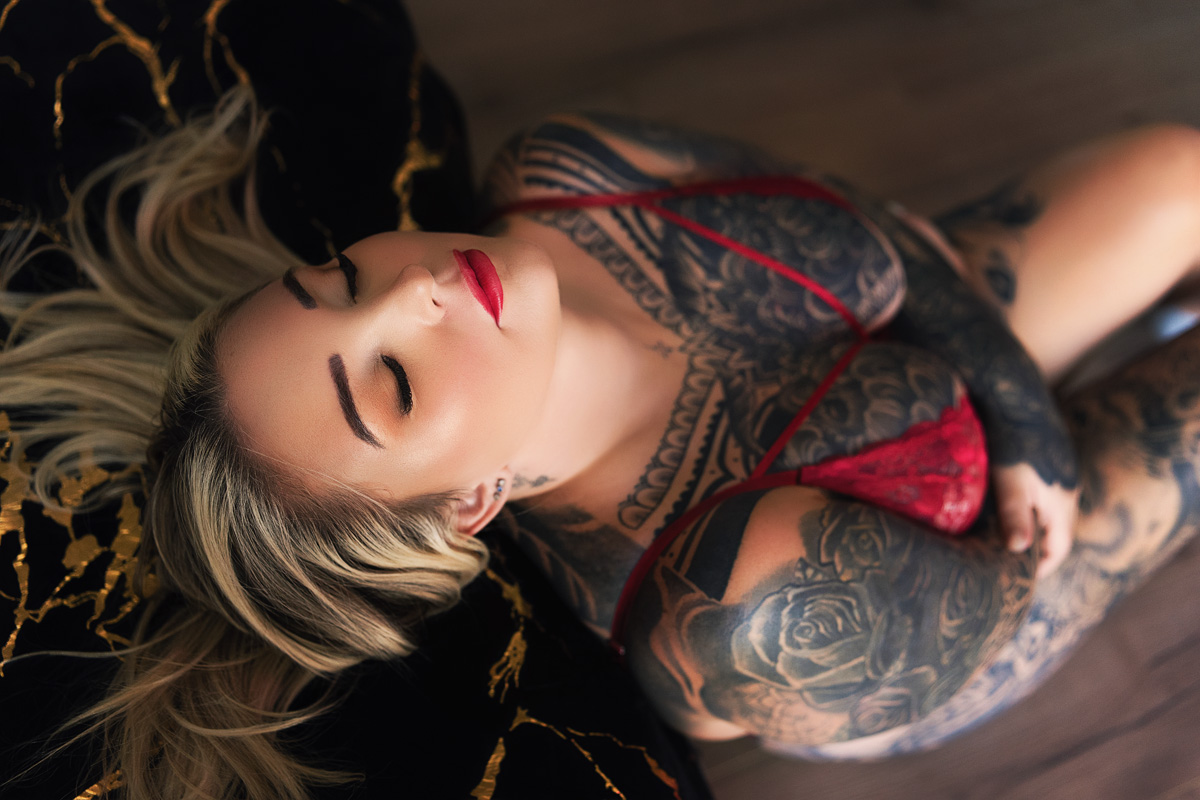 Boudoir client with tattoos in red lingerie. Glamour photography in Upper Coomera studio.