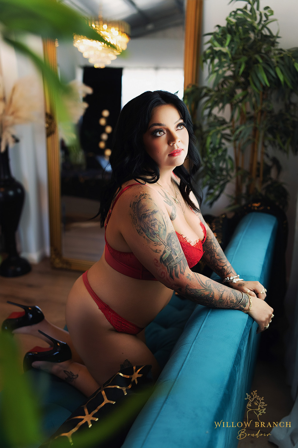 Self Care Boudoir Shoot for a mum who needed some time to recharge, posing on couch in red lingerie looking out the window.