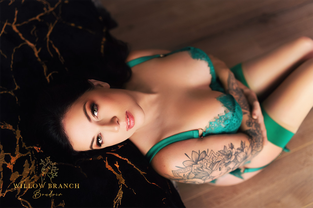 Client with tattoos sitting on the floor looking at the camera at Healing Boudoir shoot in Upper Coomera, Gold Coast.