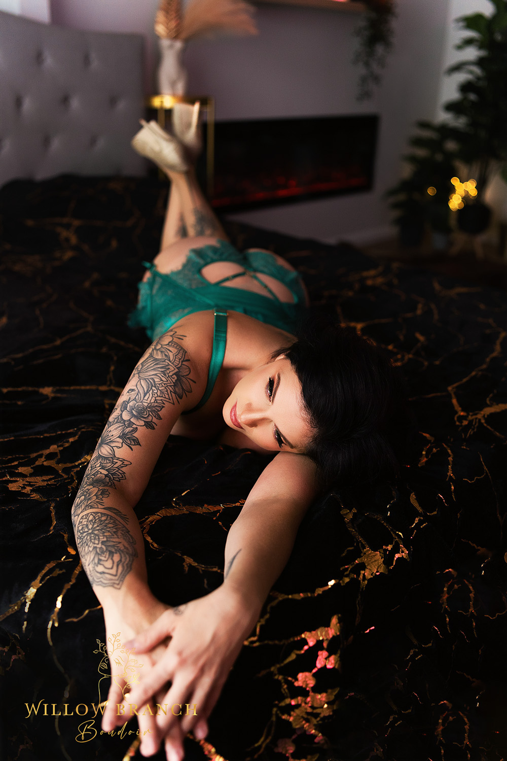 Relaxed pose of client in green lingerie on bed at boudoir session on the Gold Coast.