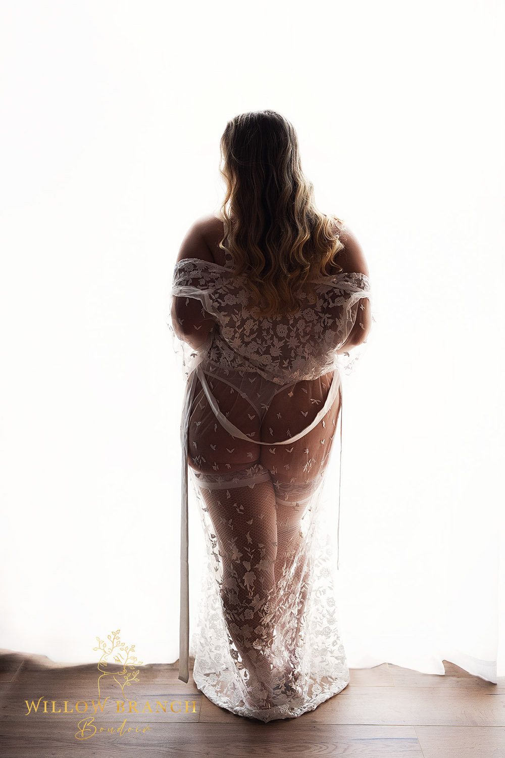 Silhouette of boudoir client in white robe in front of window at Bridal Boudoir shoot on the Gold Coast